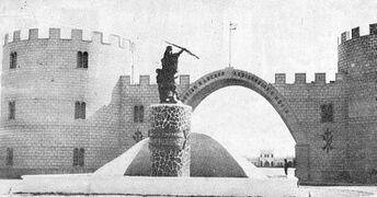 Arco de entrada al Acuartelamiento de Villa Cisneros, con el monumento al espíritu de compañerismo en primer término